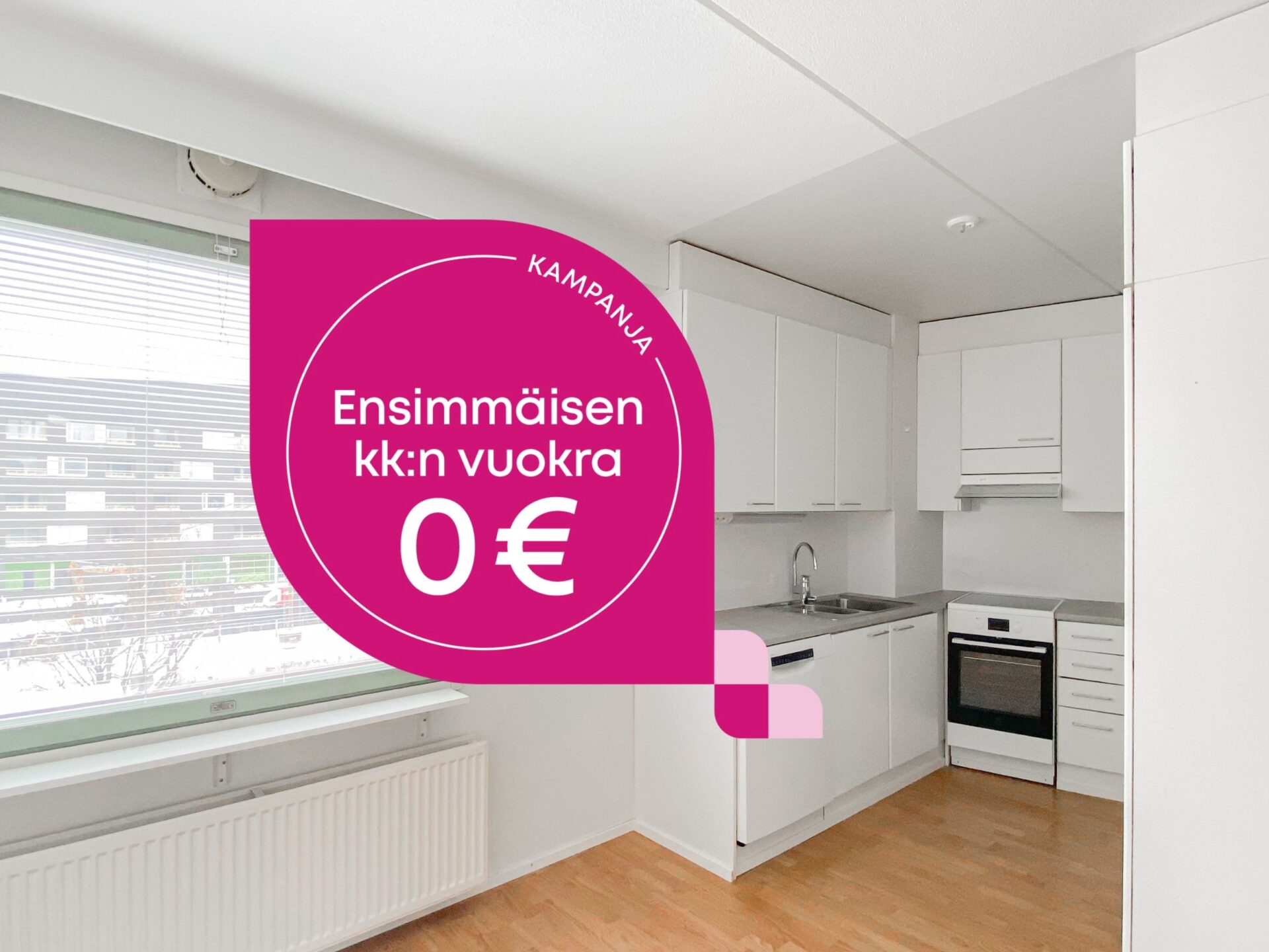 Keittiö, jossa on valkoiset kaapit ja kodinkoneet, ja sen vieressä mainoskuva, jossa tarjotaan ensimmäiset kuukaudet vuokraa 0 euroa.