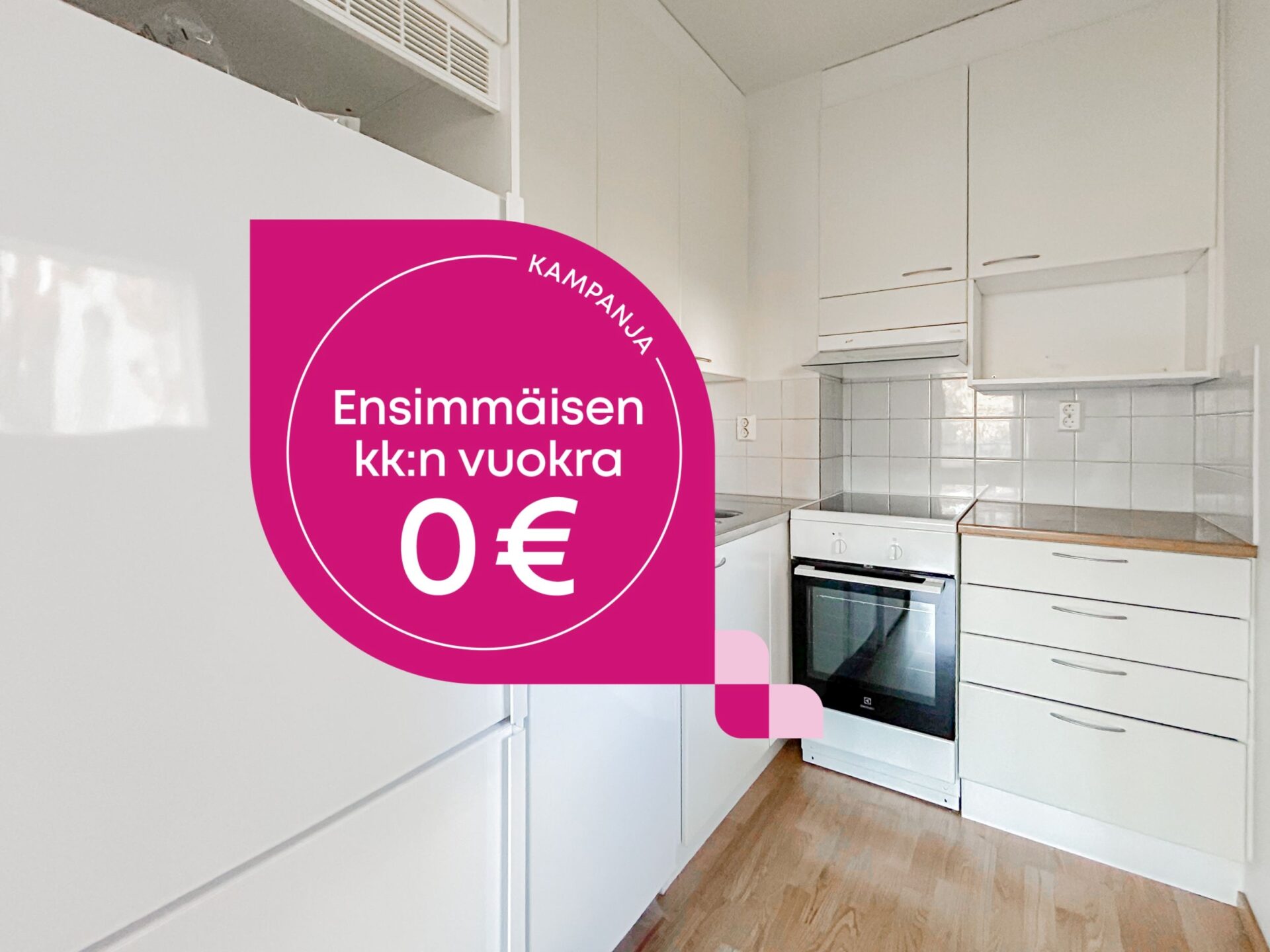 Keittiö, jossa on valkoiset kaapit ja valkoinen liesi, ja jonka päällä on vaaleanpunainen mainosgrafiikka, jossa lukee: KAMPANJA Ensimmäisen kk:n vuokra 0 €.