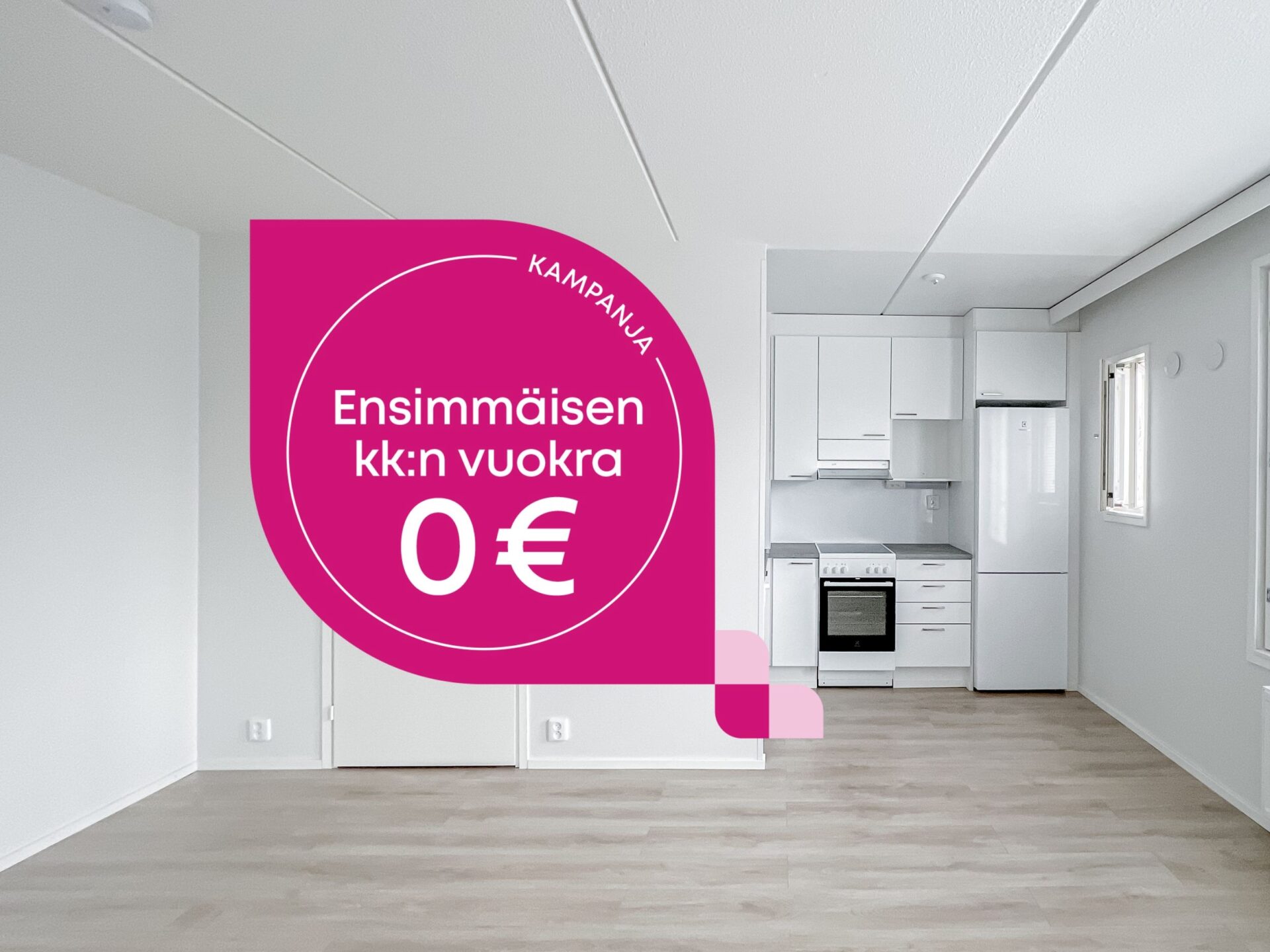 Tyhjä asunto, jossa on pieni minikeittiö ja vaaleanpunainen mainoskyltti, jossa lukee: KAMPANJA Ensimmäisen kuukauden vuokra 0 €.