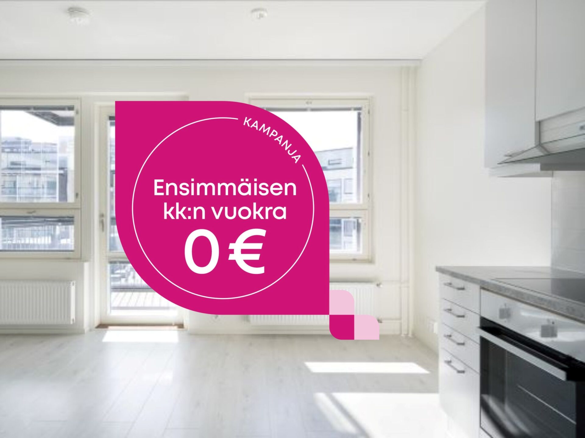 Tyhjä asunnon keittiö ja olohuone, jossa on vaaleanpunainen mainosgrafiikka, jossa lukee: Kampanja: Ensimmäisen kk:n vuokra 0 €.